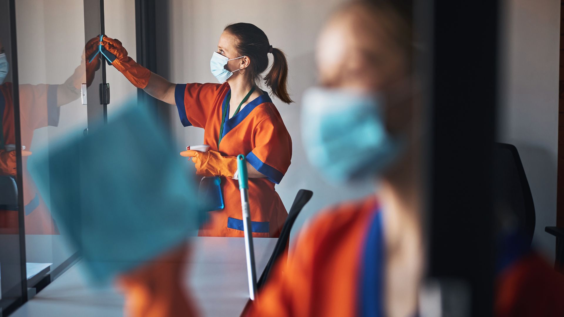 2 cleaners cleaning office window