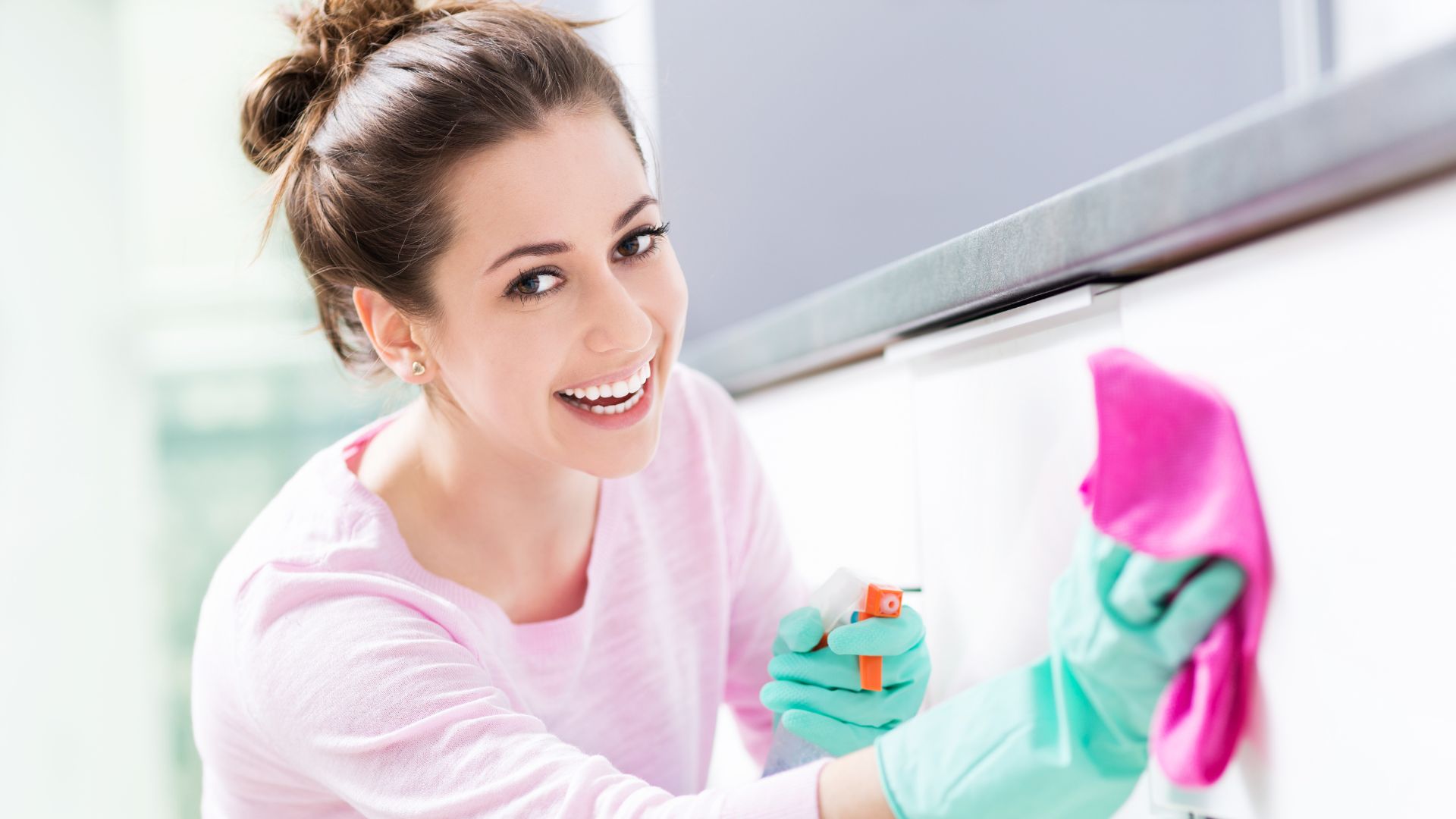 Maid wiping cabinet